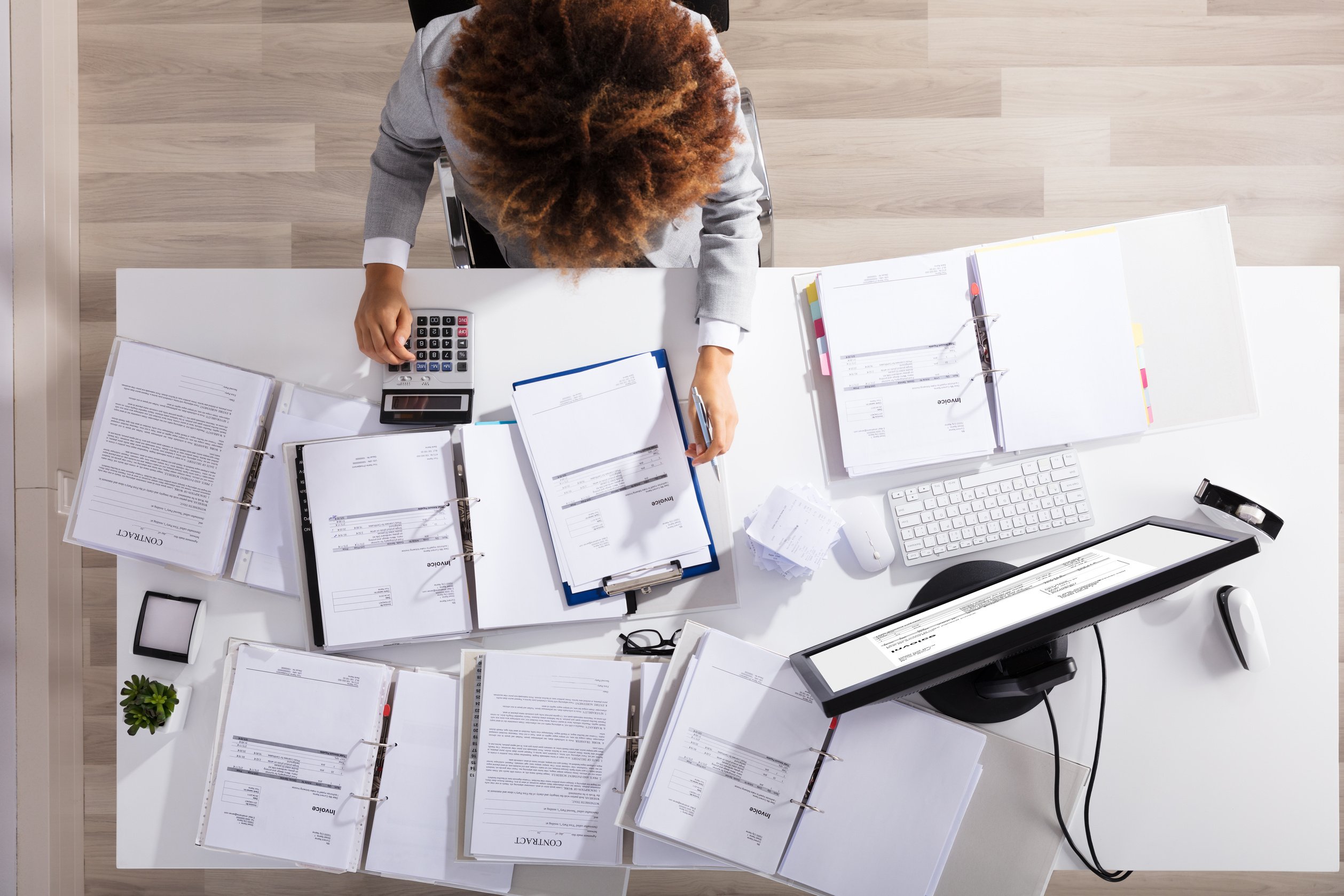 Businesswoman Calculating Invoice In Office